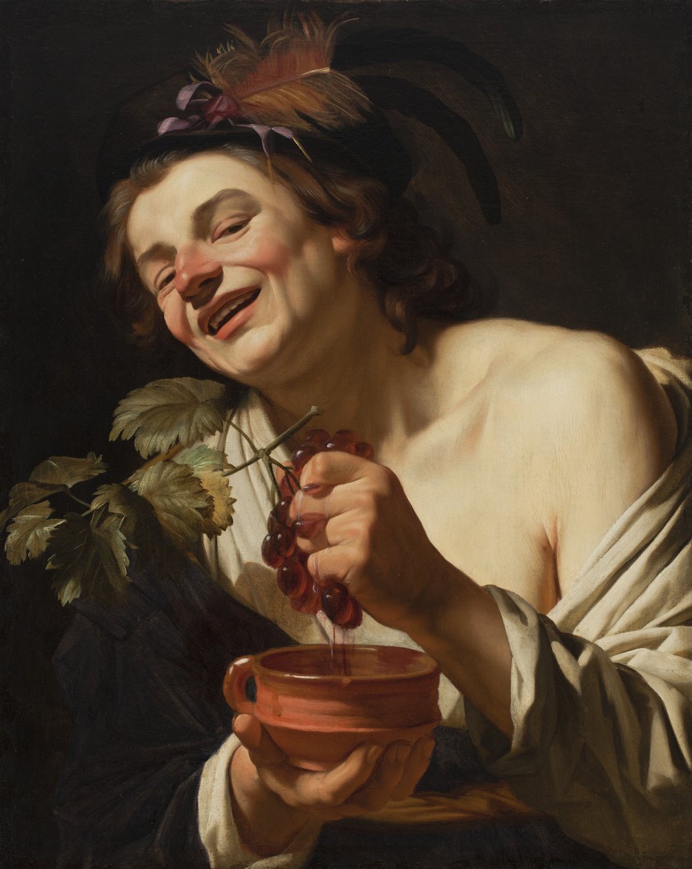 Leende ung man som pressar druvor, 1622 av Gerrit van Honthorst