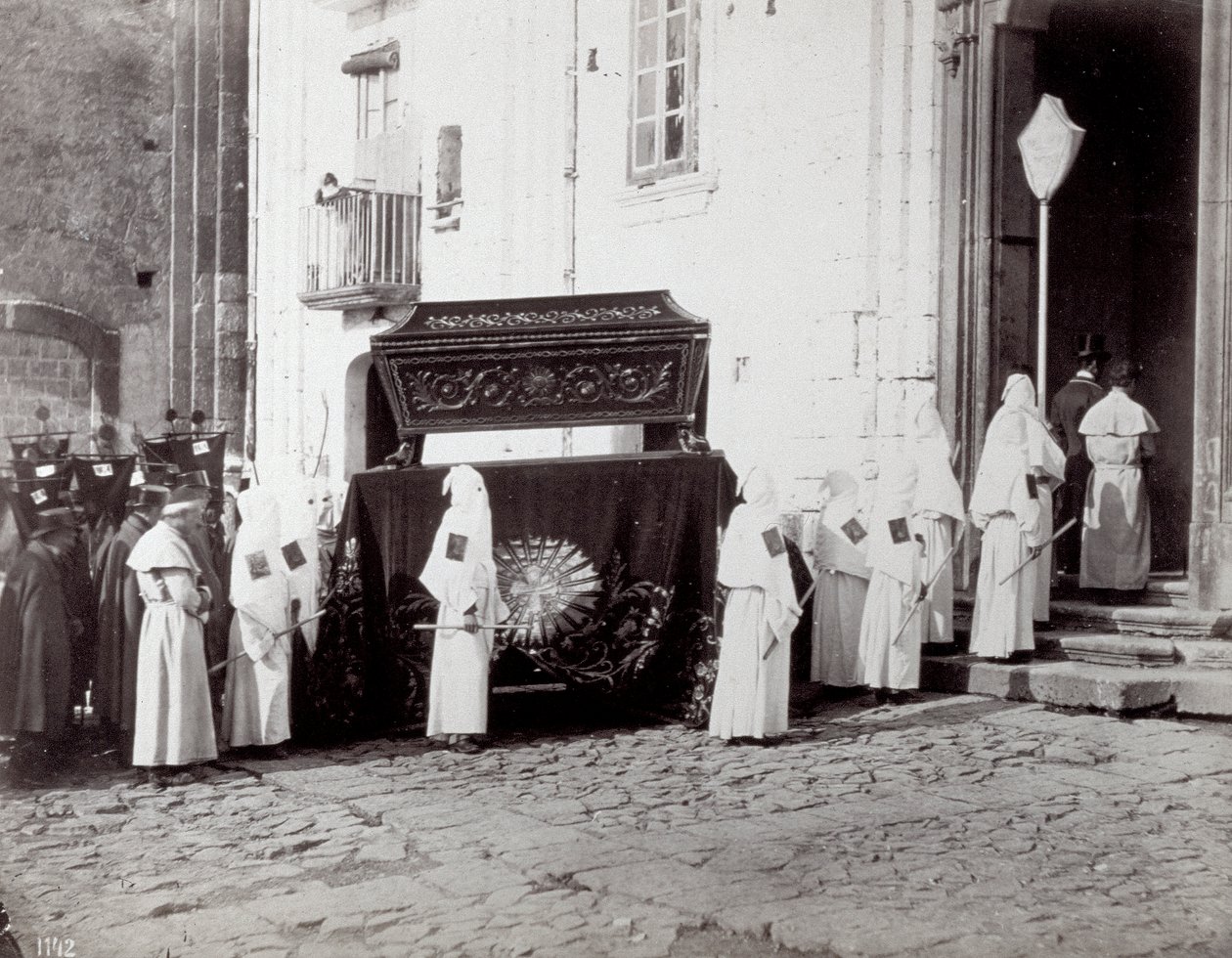 Begravningståget för kongregationen San Francesco i Neapel. I förgrunden, framför en kyrka, följer många "bröderskapsbröder" i vita tunikor och huvor en katafalk dekorerad med ett broderat tyg som kistan är placerad på av Giorgio Sommer