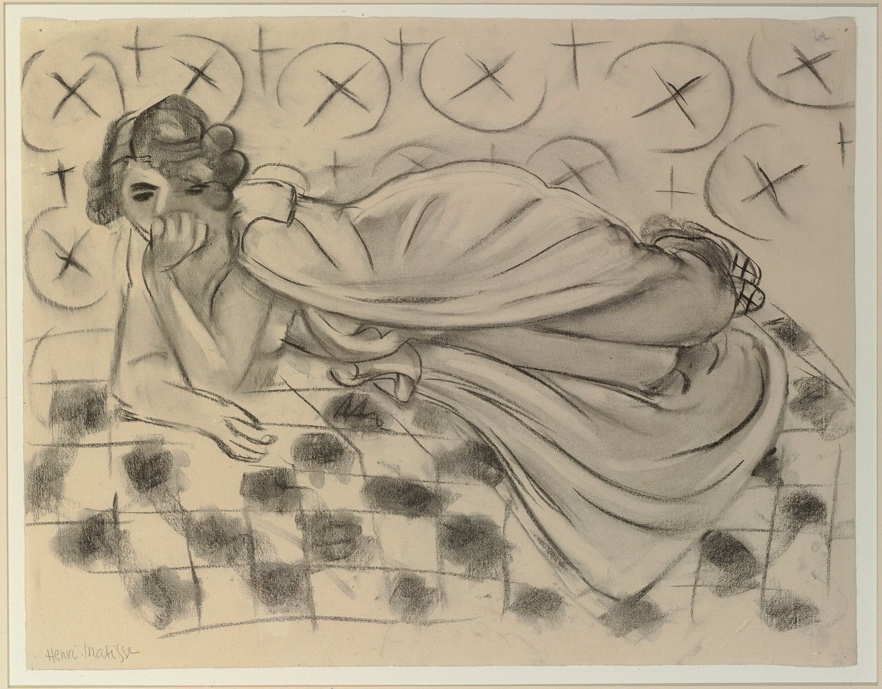 Draperad figur liggande på en svartrutig soffa av Henri Matisse