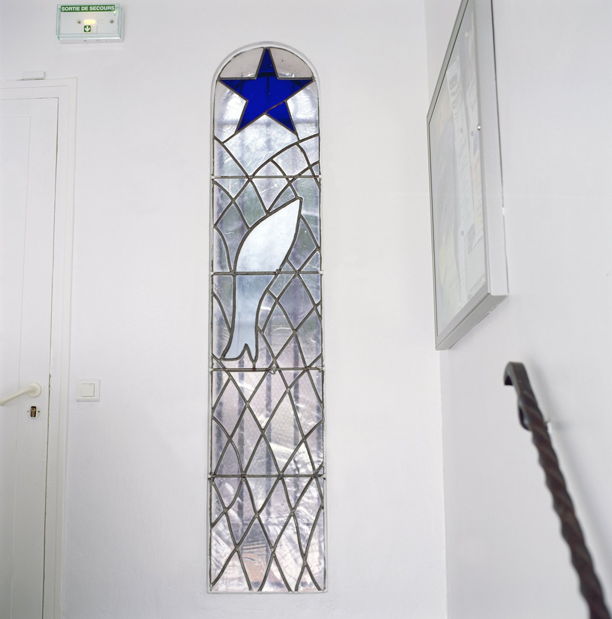 Glasmålning föreställande en fisk fångad i ett nät under Frälsningsstjärnan, från trappan till Rosenkransens kapell av Henri Matisse