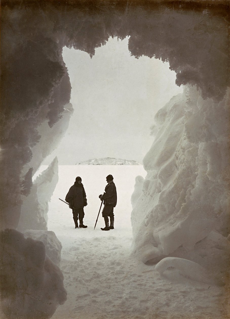 Män utanför en grotta uthuggen ur isen under en expedition till Antarktis av Herbert Ponting