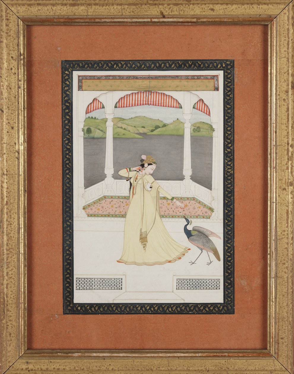 Dam som lockar en påfågel med en pärlsträng, ca 1800 (gouache och guld på papper) av Indian School