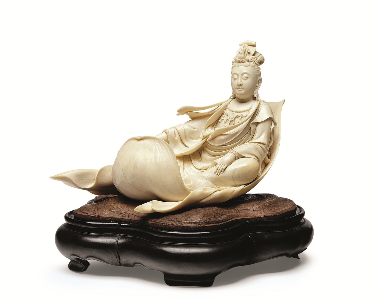 En elfenbensristning av Kannon flytande på ett lotusblad, Meiji-period, sent 1800-tal (elfenben med trästativ) av Ishikawa Komei