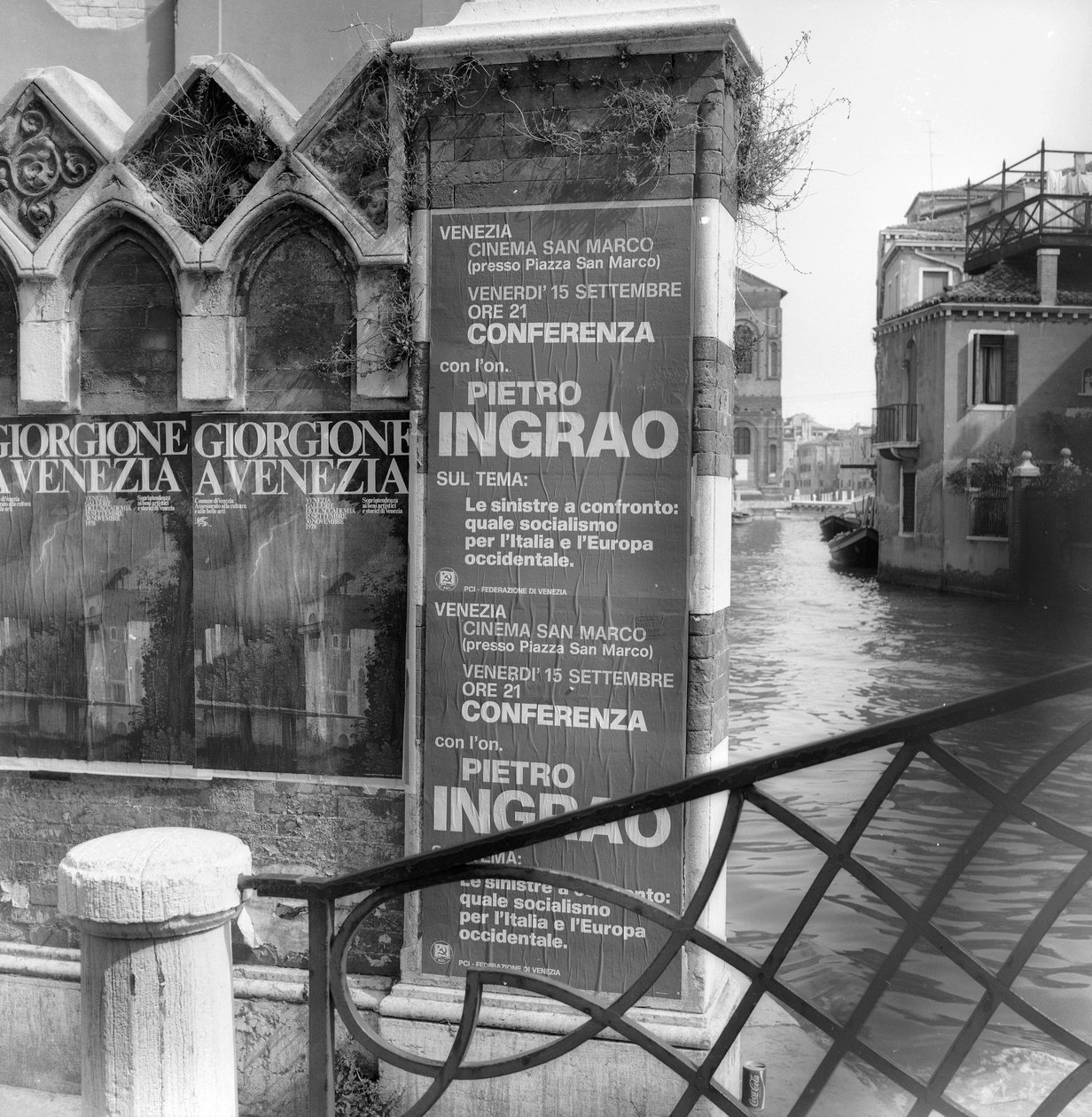 Utsikt över en kanal i Venedig med affischer som annonserar en Giorgione-utställning och ett politiskt manifest i förgrunden av Italian Photographer
