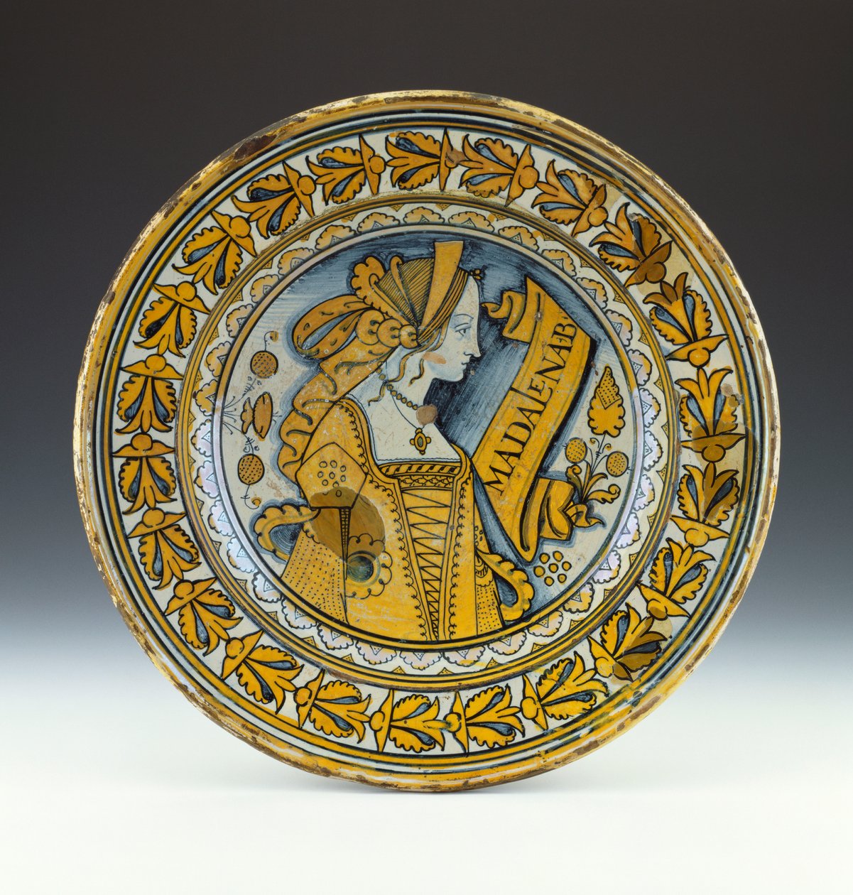Ett Deruta-porträttfat i blått och guld som föreställer en ung kvinna i profil och inskrivet Madalena B, c.1525 (lustred keramik) av Italian School