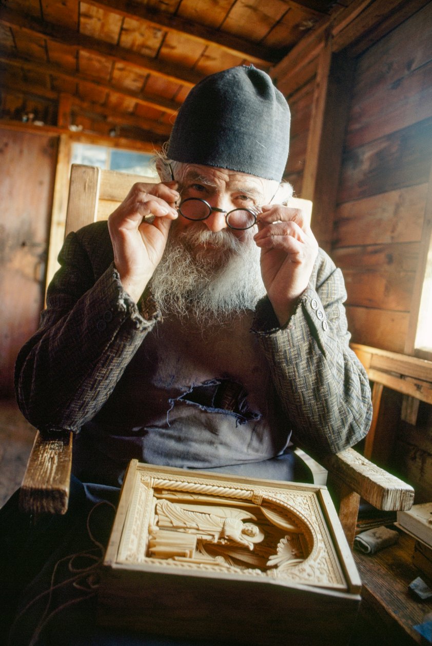 En mästersnidare och ortodox präst poserar med sitt verk. Berget Athos, Grekland. av James L Stanfield