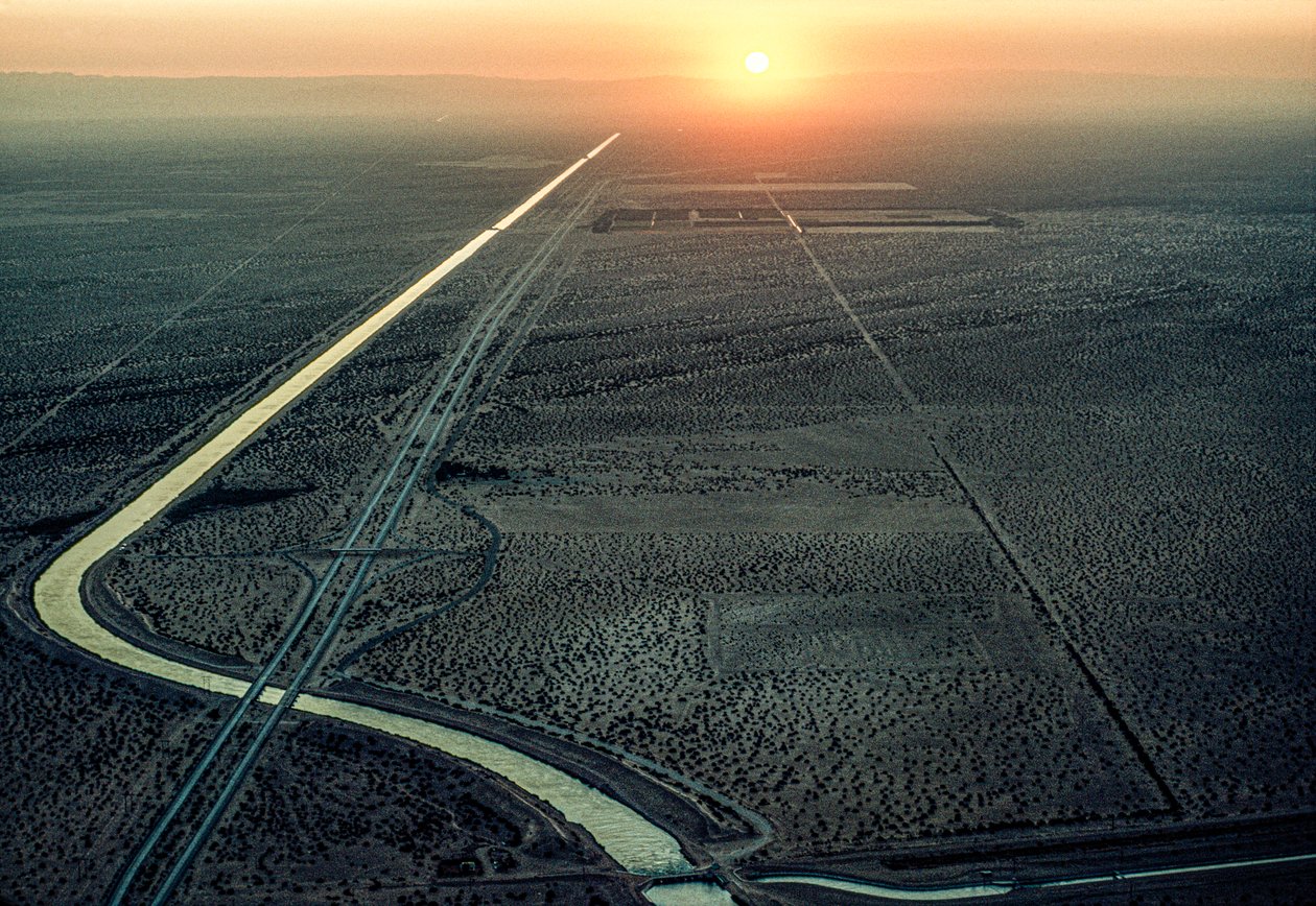 Flygfoto över All-American Canal medan den gassande solen går ner i väster. Kanalen... av James L Stanfield