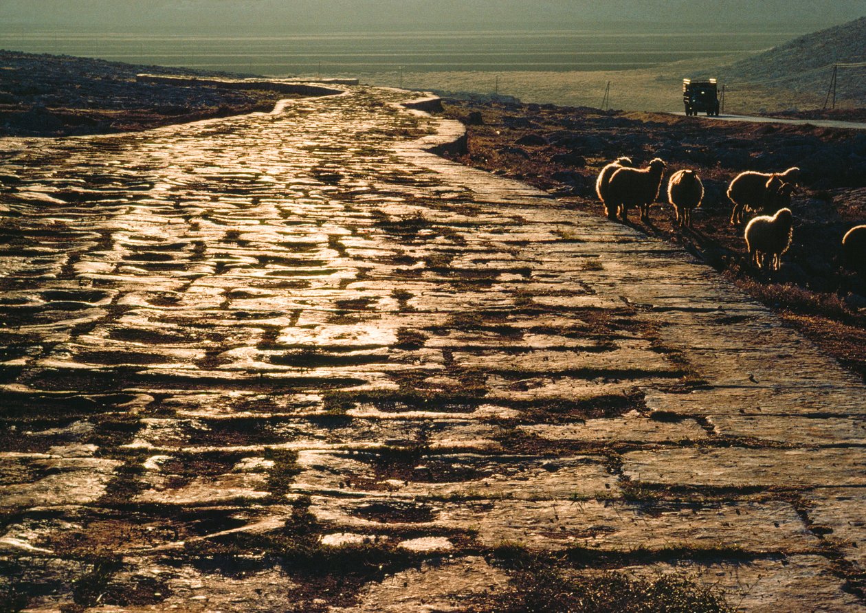 Modern makadamväg går parallellt med gammal romersk väg av kalksten. Nära Aleppo, Syrien. av James L Stanfield
