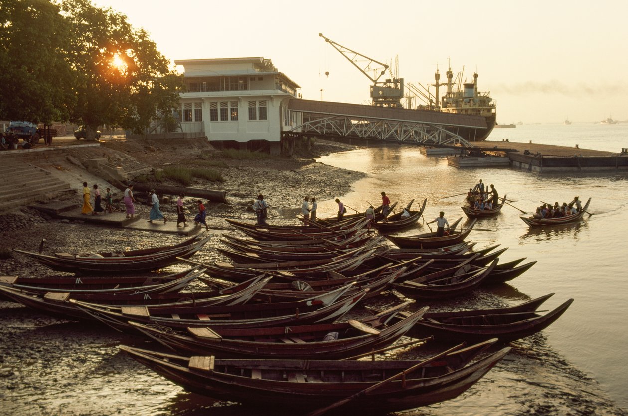 Sampans trängs på den leriga stranden vid Nantira Jetty. NANTIRA BRYGGA, RANGOON, BURMA. av James L Stanfield