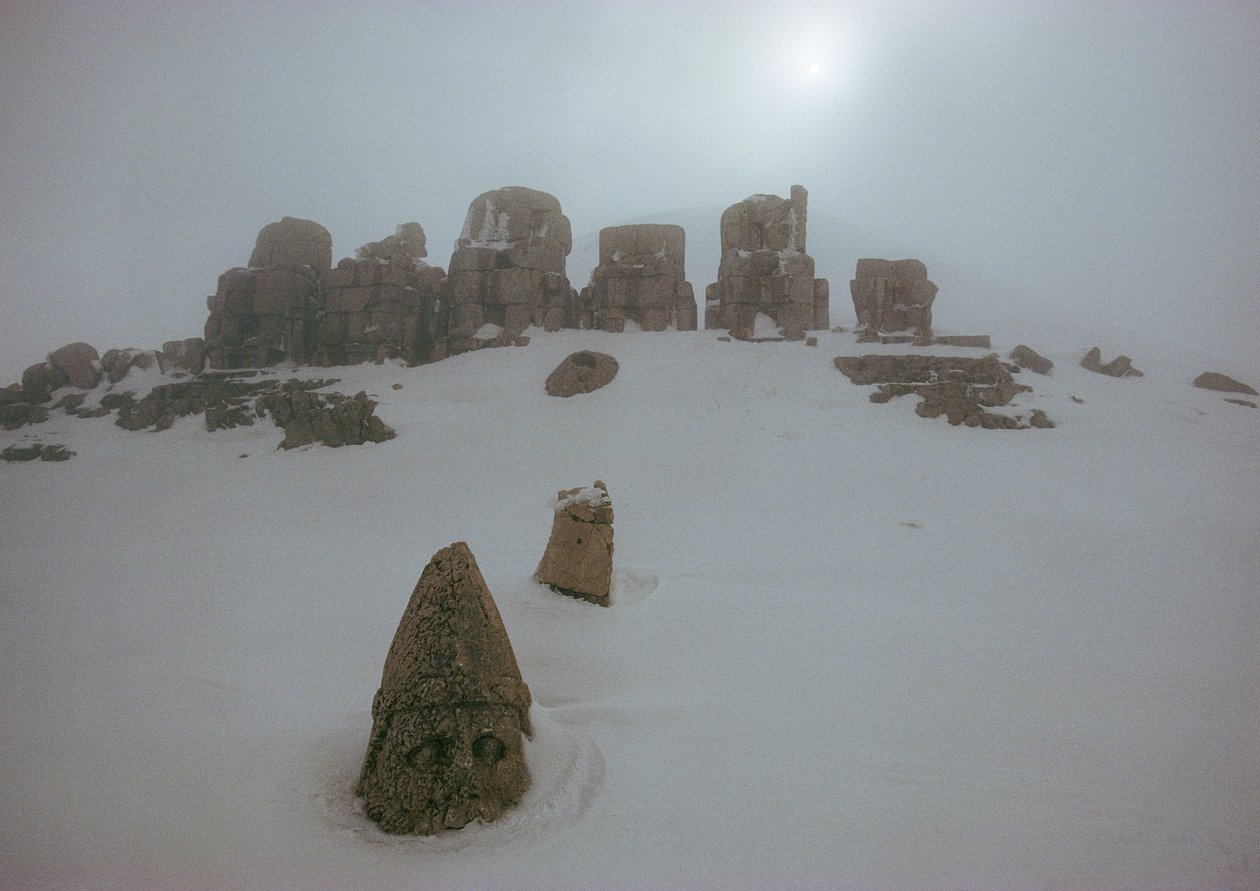 Staty av en gud över ett snötäcke vid Nemrud Dagh. Nemrud Dagh, Turkiet. av James L Stanfield