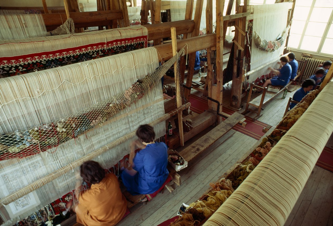 Kvinnor arbetar vid en stor vävstol för mattvävning. Kotel, Bulgarien. av James L Stanfield