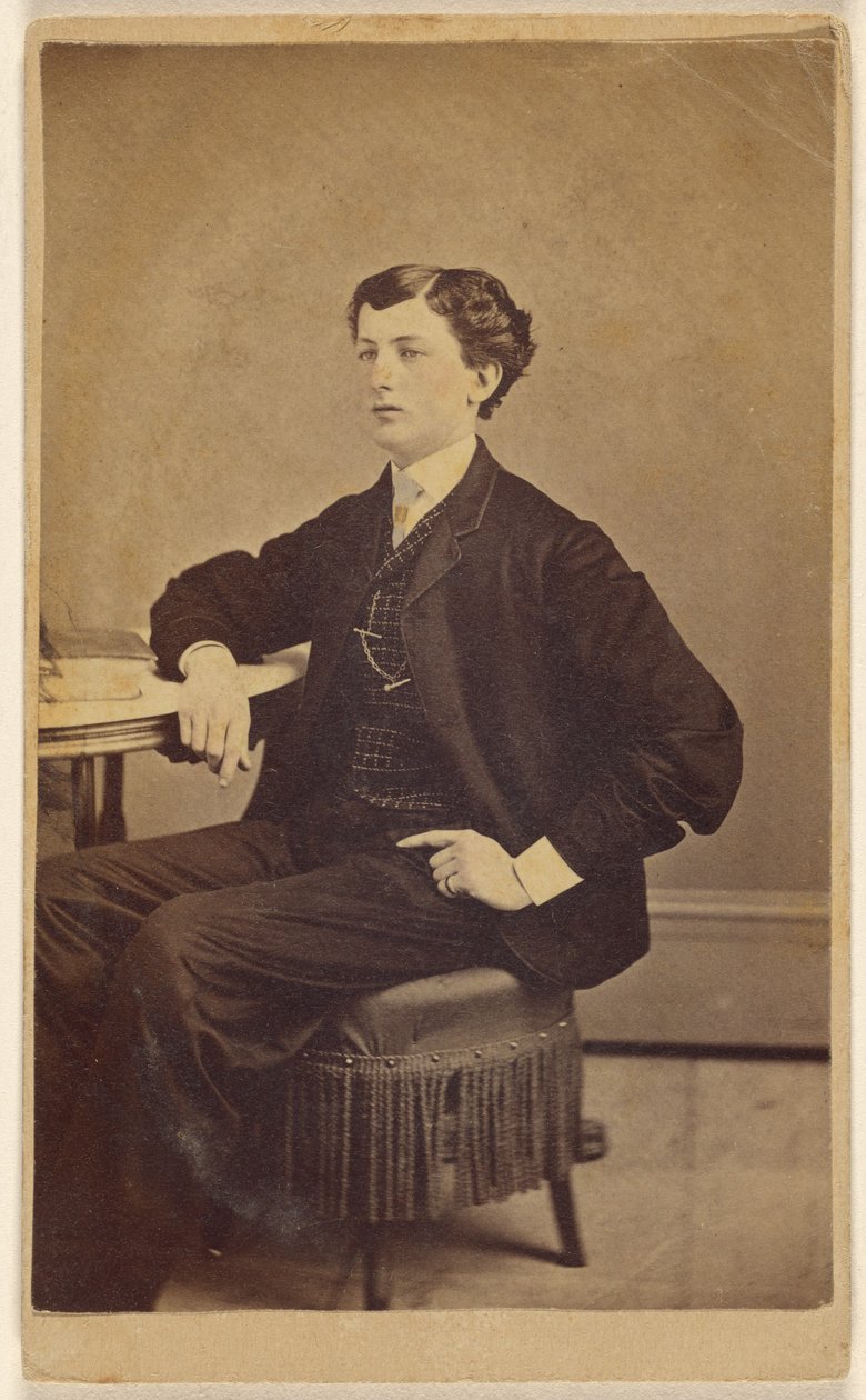 [Oidentifierad ung man sitter vid ett bord] av James S. Woodley