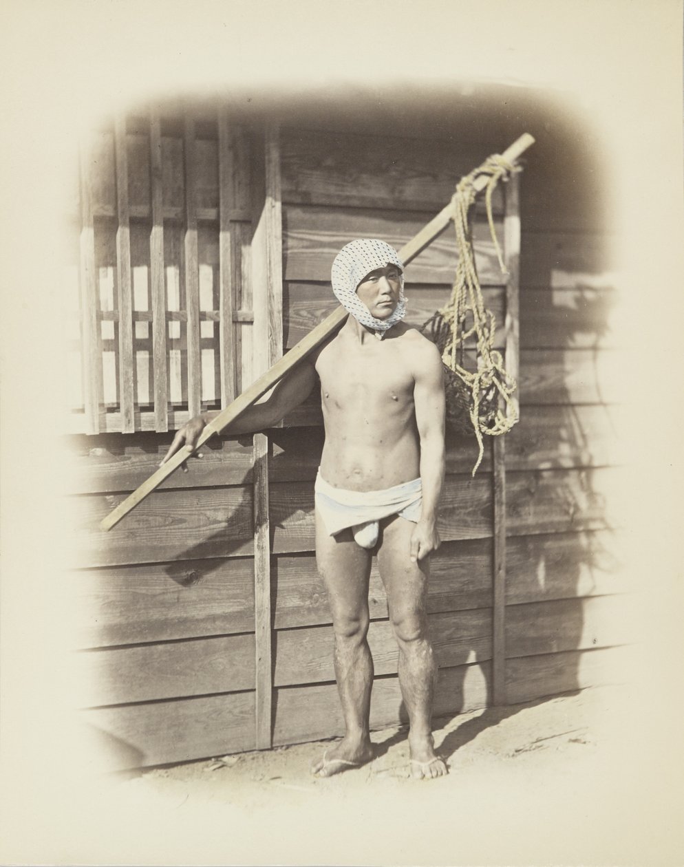 Man med fiskekorg (handfärgat svartvitt foto) av Japanese Photographer