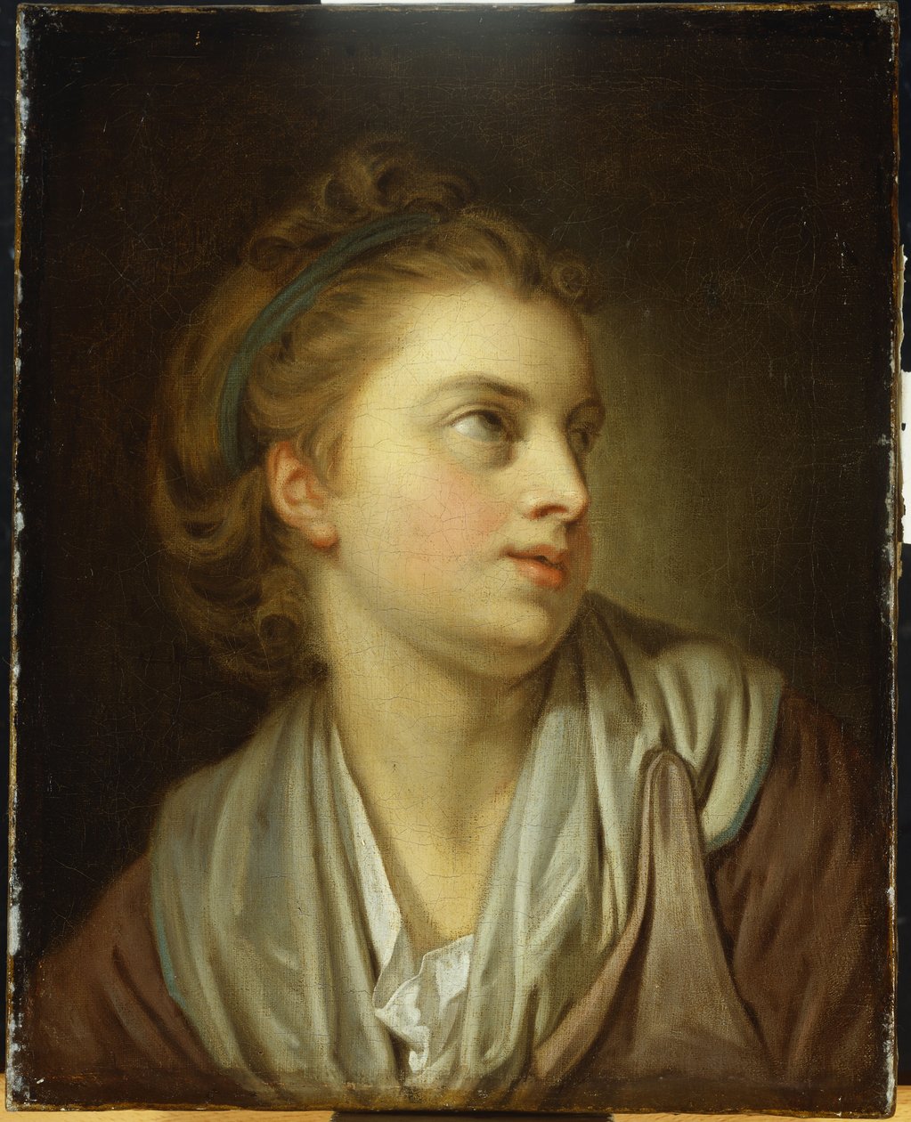 En flicka, byst lång, med ett grönt hårband, tittar upp av Jean Baptiste Greuze