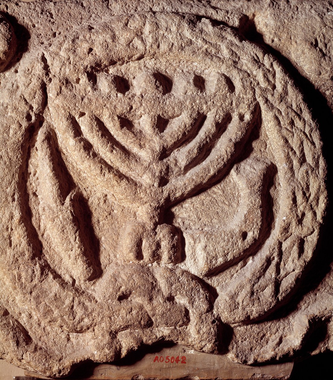 Judendom: arkitektoniskt element i basalt av en synagoga dekorerad med en ljusstake med sju grenar (menora eller menora), palm och trumpet. Från Transjordan. Omkring 100 e.Kr. Paris, Louvren av Jewish School