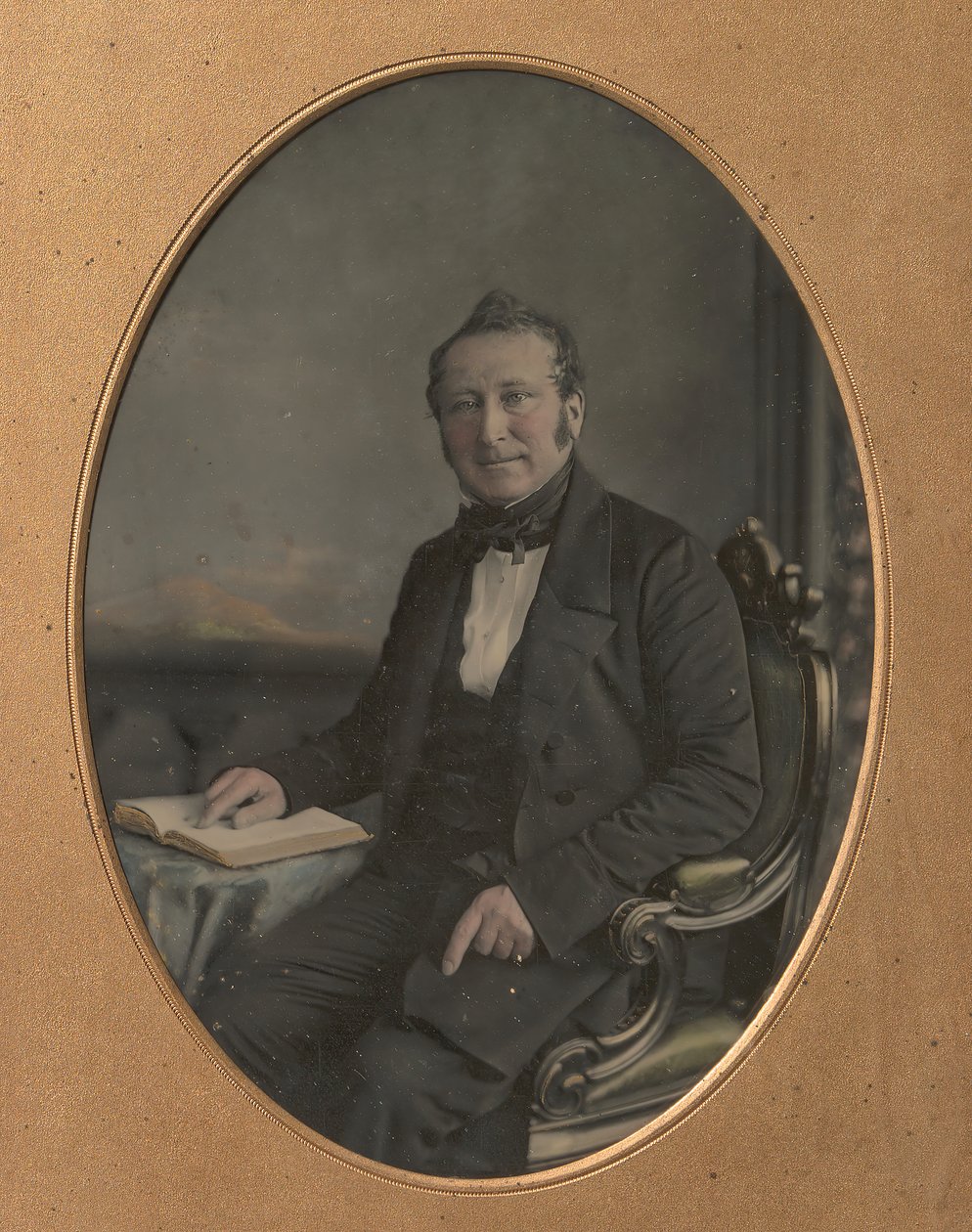 Sittande man som pekar på en passage i en öppen bok, 1850-talet. av John Jabez Edwin Mayall