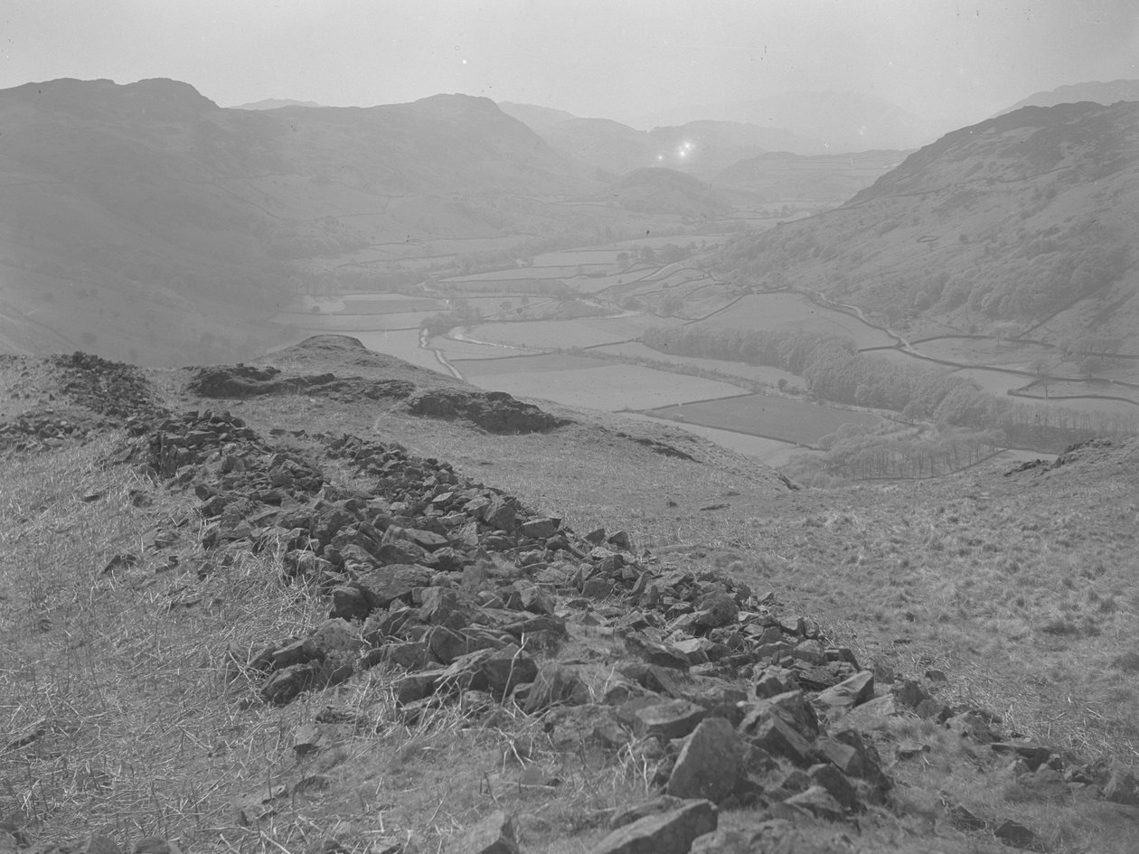 Utsikt över en öppen dal vid Hardknott med högar av stenar i förgrunden av Joseph Hardman