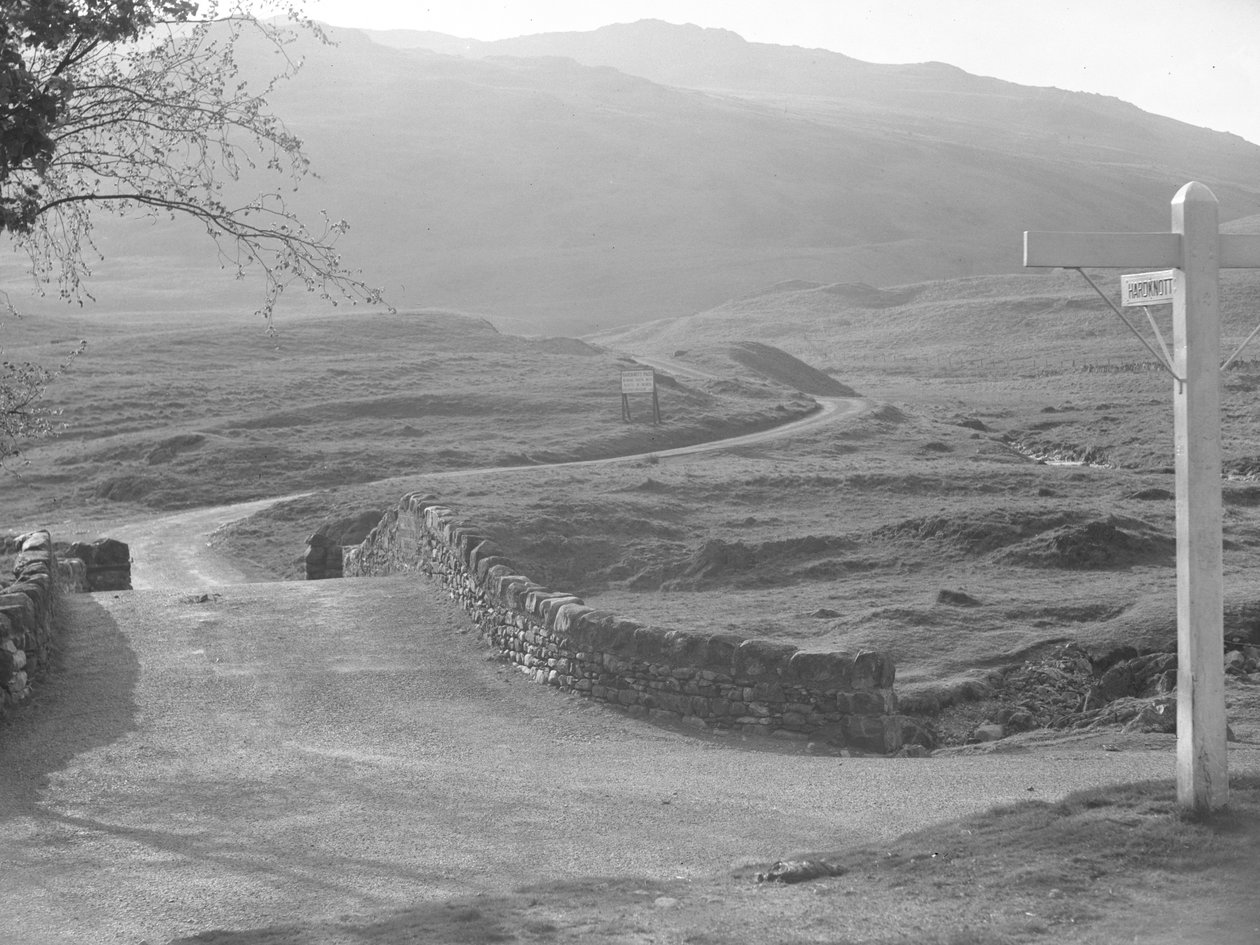 Vy över vägen som passerar över Hardknott Pass med en skylt som pekar i riktning mot Hardknott av Joseph Hardman