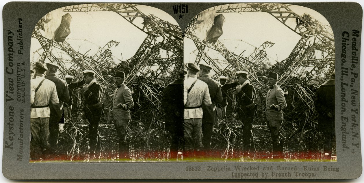 Horizontal, sepia stereocard showing group of uniformed men surveying the wreckage of a zeppelin. Keystone Stereograph number 18632. The title reads av Keystone View Company