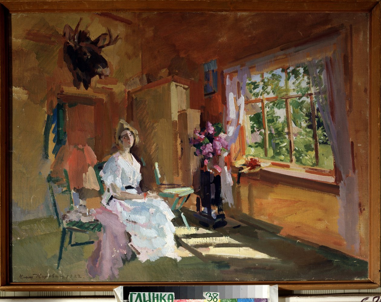 I rummet. Ung kvinna i en ljus klänning, sittande framför fönstret, genom vilket vi kan se trädgården, högsommar. Målning av Konstantin Alexeyevich Korovin (1861-1939), olja på duk av Konstantin Alekseevich Korovin