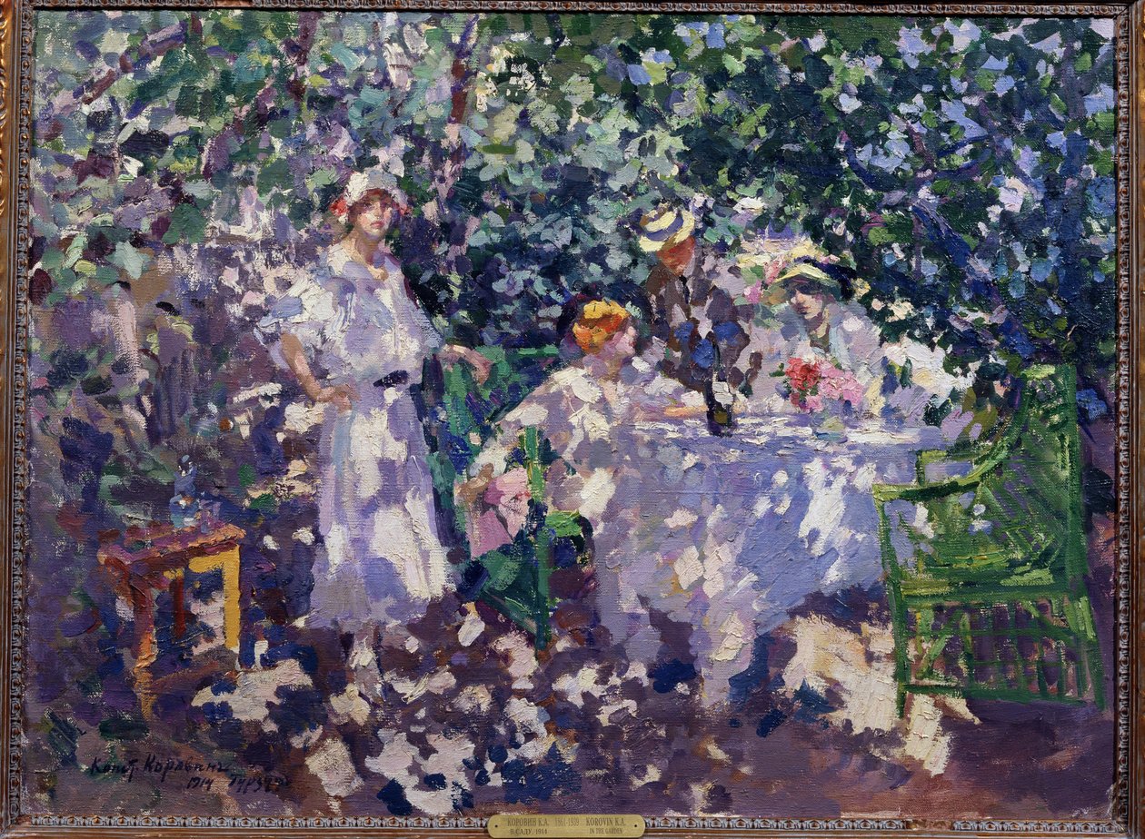 I trädgården (In the Garden). Ett bord dukat i lundarna, på sommaren, drar tre unga kvinnor och en man, sittande, iförda stråhattar, fördel av skuggan. Målning av Konstantin Alexeyevich Korovin (Constantin Korovin) (1861-1939), olja av Konstantin Alekseevich Korovin