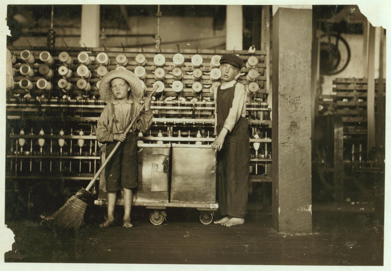 12-åriga doffer Ronald Webb och 7-årige Frank Robinson, son till cardroom boss, som sveper och tar bort (rensar hela bobiner) vid Roanoke Cotton Mills, Virginia, 1911 av Lewis Wickes Hine