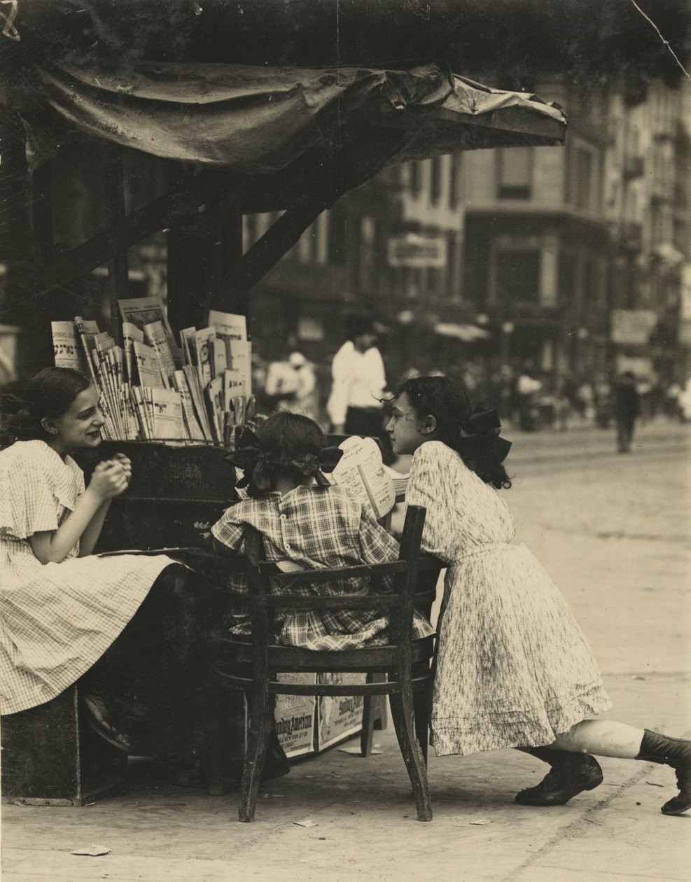 Tre unga flickor arbetar i ett tidningsstånd på Canal Street i New York City av Lewis Wickes Hine