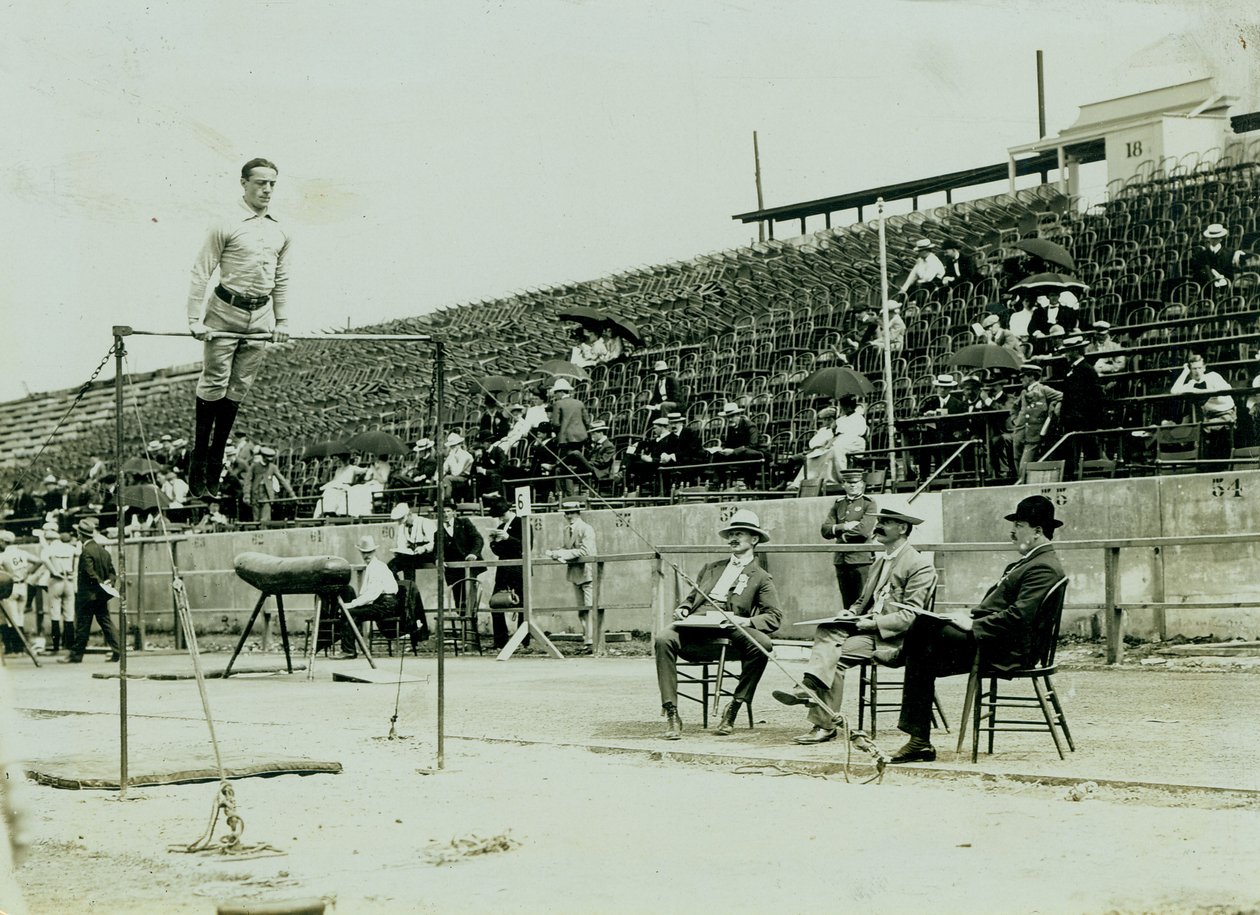 Horizontal photograph of an athlete on a high bar with three judges looking on av Louis Melsheimer