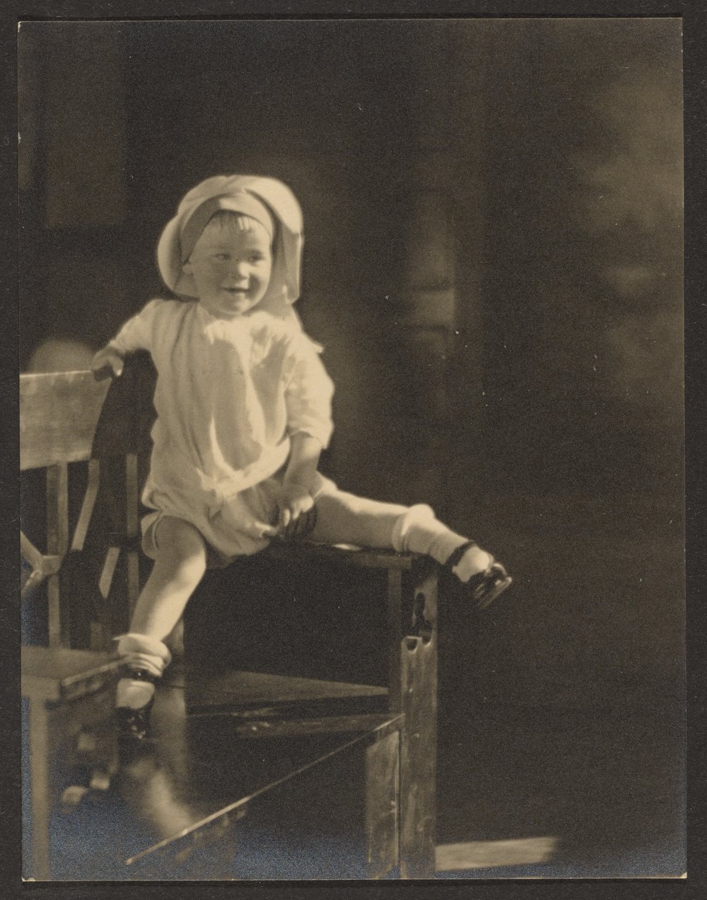 [Baby som sitter på en bänk] av Louis Fleckenstein
