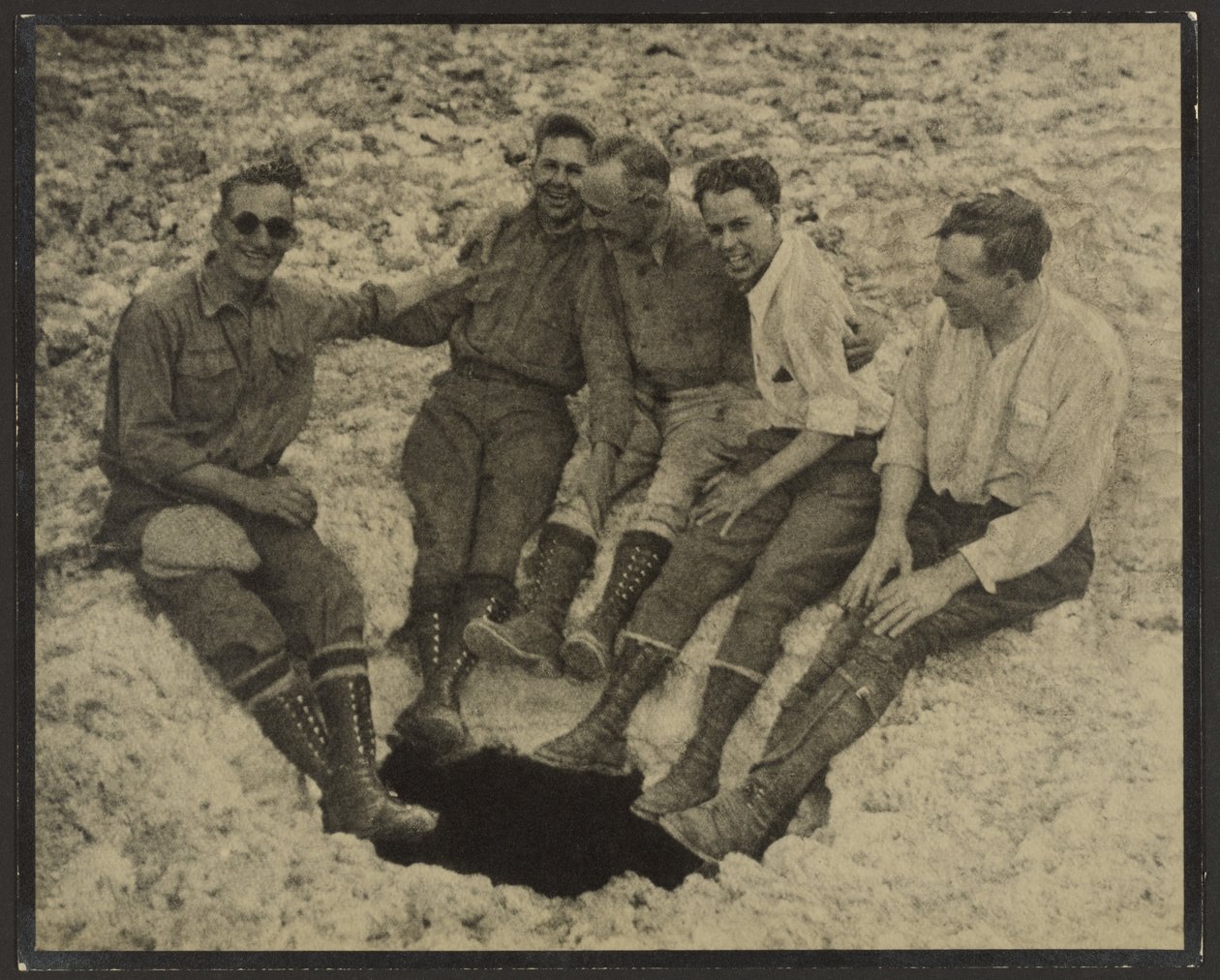 [Gruppporträtt av personer sittande vid mynningen till en vertikal grotta, San Jacinto Peak] av Louis Fleckenstein