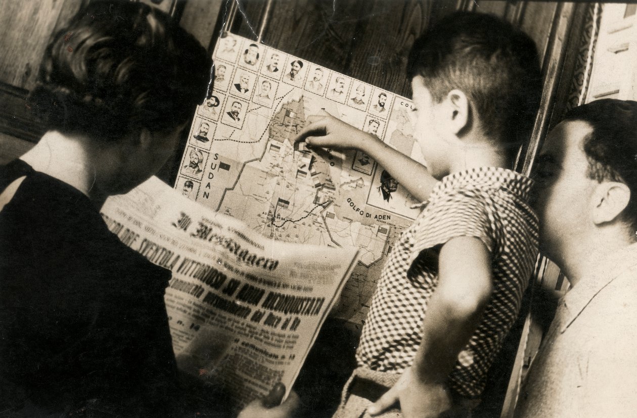En kvinna läser framsidan av The Messenger med titeln "Trikoloren vajar segrande av Adwa återerövrade" av Luigi Leoni