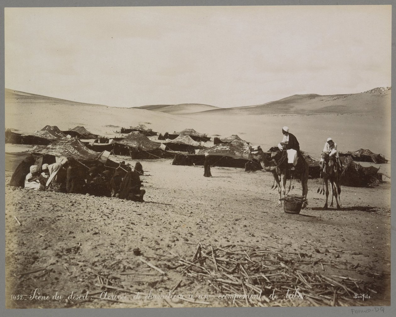 Läger med tält och kameler i (förmodligen) Egyptens öken Scene du desert: Arrivée de chameliers à un campement de tribu. (titel på objekt) av Maison Bonfils