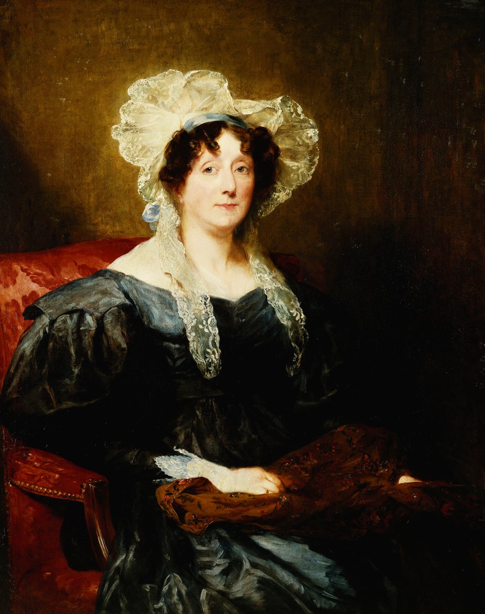 Porträtt av en dam, sittande halvlängd, i en mörkblå klänning och en vit spetshuv med en blå rosett, med handarbete, av Margaret Sarah Carpenter