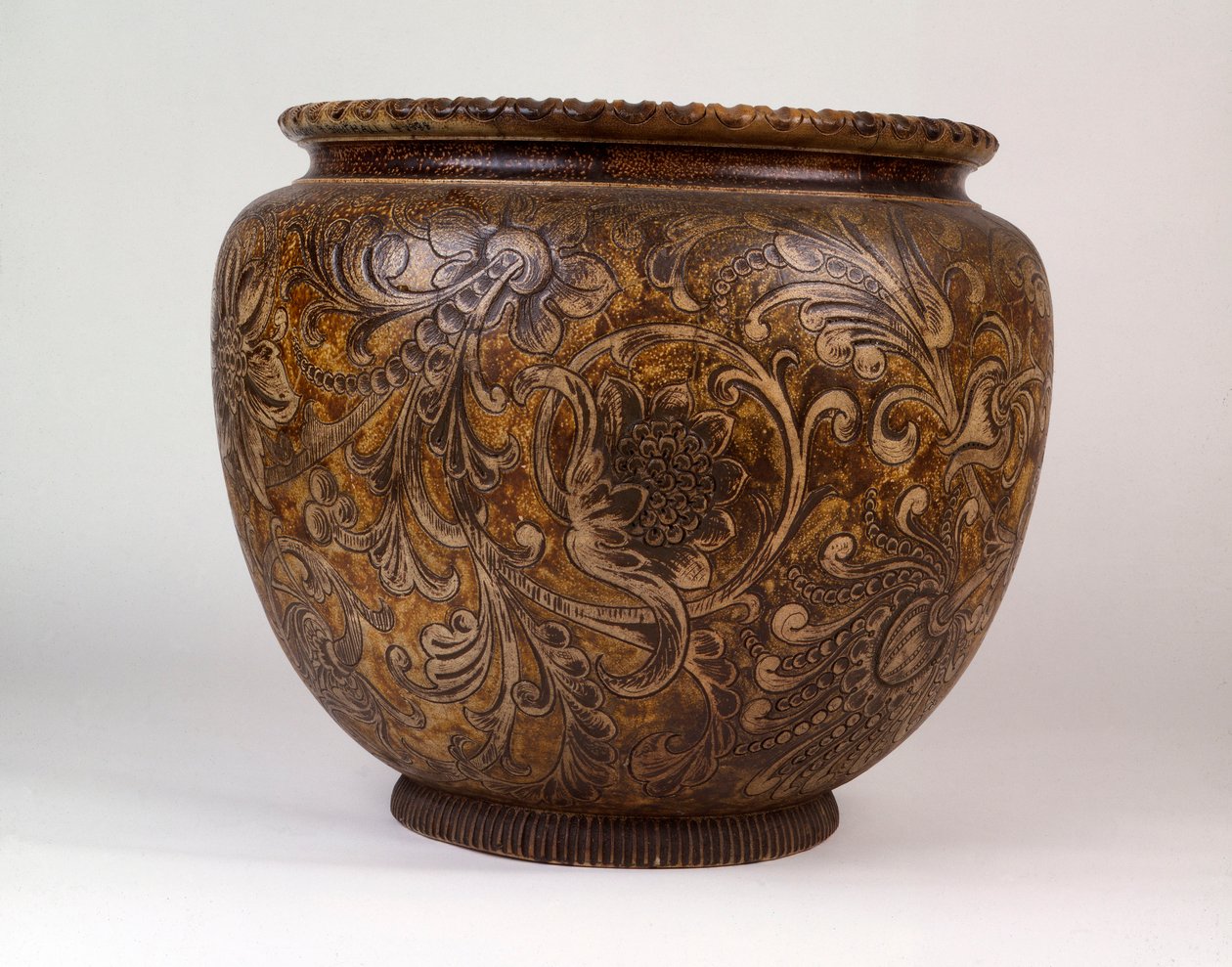 En stor Martin Brothers jardiniere dekorerad med rullande växter och bladverk, 1888 av Martin Brothers