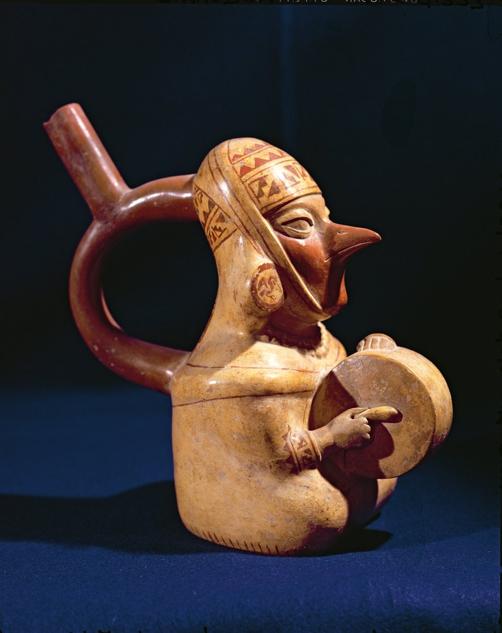 Stigbygelvas i form av en man som spelar trumma, 200-800 (keramik) av Moche