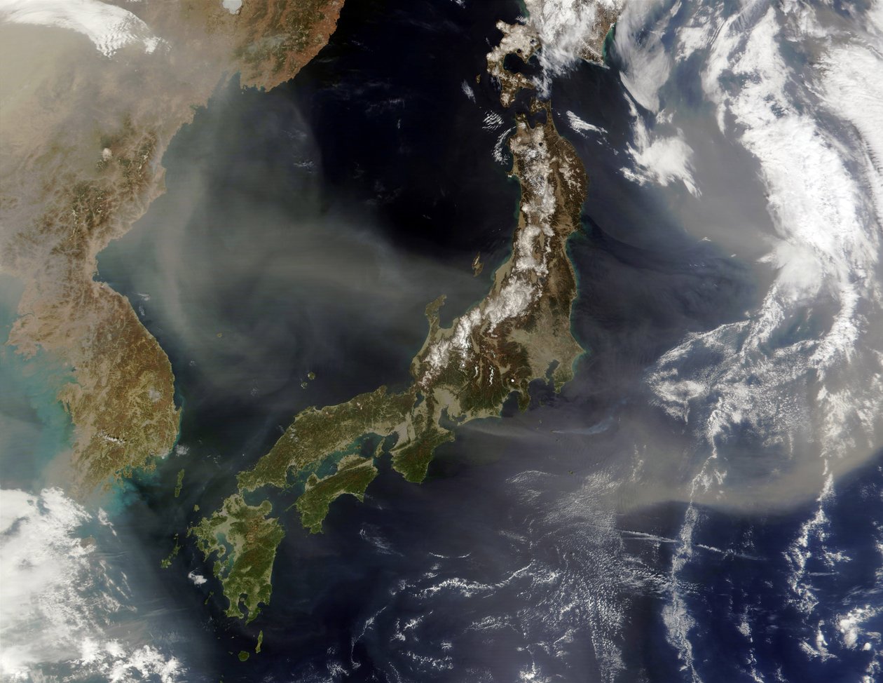Satellitvy över Japan med snötäckta berg, vårgrönande land på lägre nivåer. Damm från det kinesiska fastlandet blåser över Japanska havet och ut i Stilla havet. Kredit: NASA. Vetenskap av National Aeronautics and Space Administration National Aeronautics and Space Administration