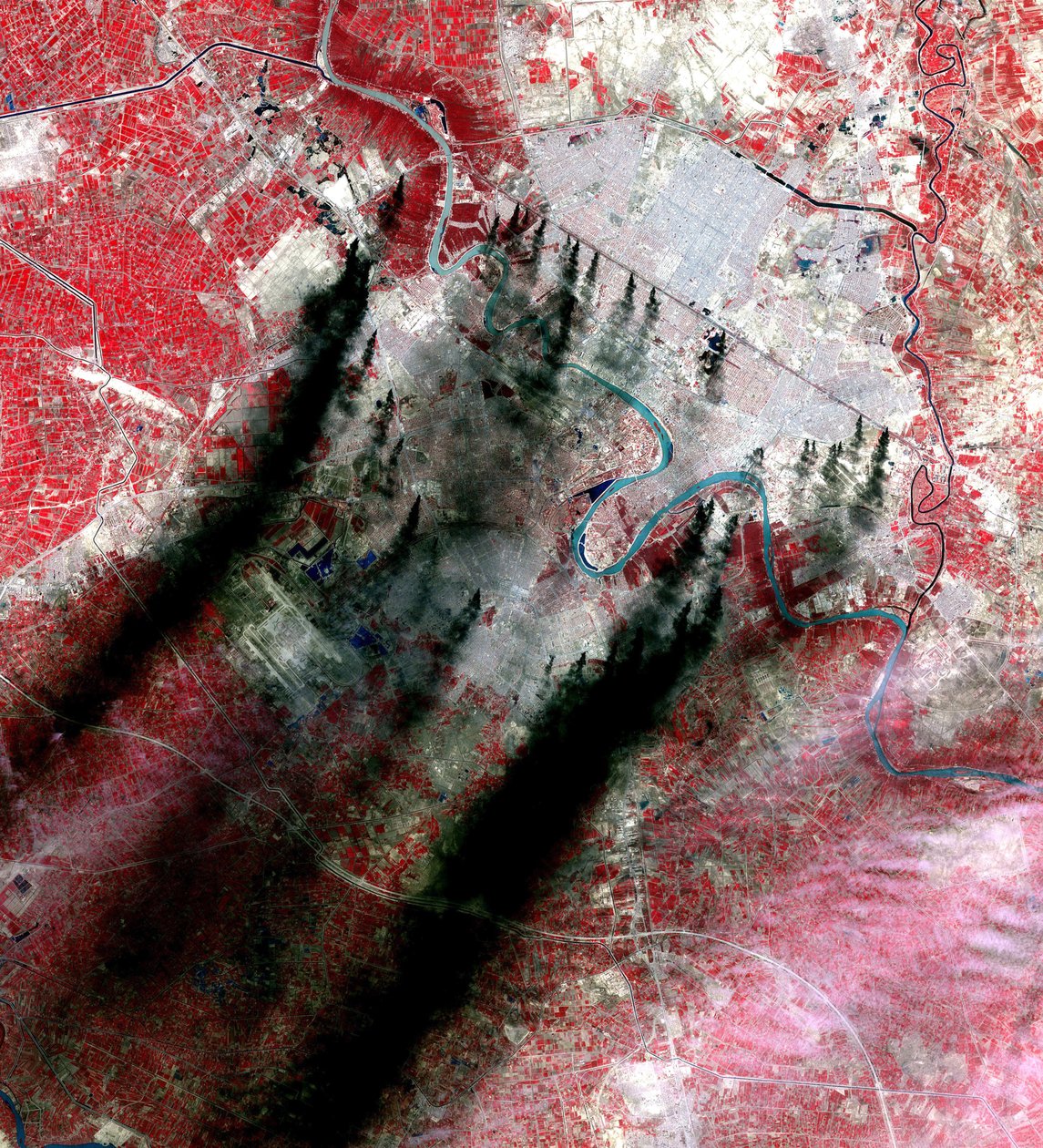 Rökplymer ovanför Bagdad Irak, som har sitt ursprung längs stora vägar och kanaler, tros vara brinnande oljepölar från rörledningar. Tagen av NASA under invasionen av Irak 2003. Vetenskap Jordgeologi av National Aeronautics and Space Administration National Aeronautics and Space Administration