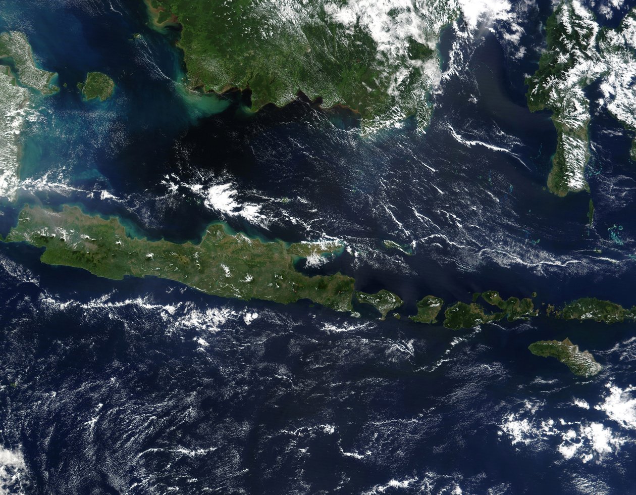 Rättfärgad satellitbild av Indonesien i mitten av maj 2002. Eftersom brinnsäsongen inte var helt igång i regionen är himlen över ön Borneo, Malaysia vid dess nordvästra kust, jämförelsevis klar. av National Aeronautics and Space Administration National Aeronautics and Space Administration