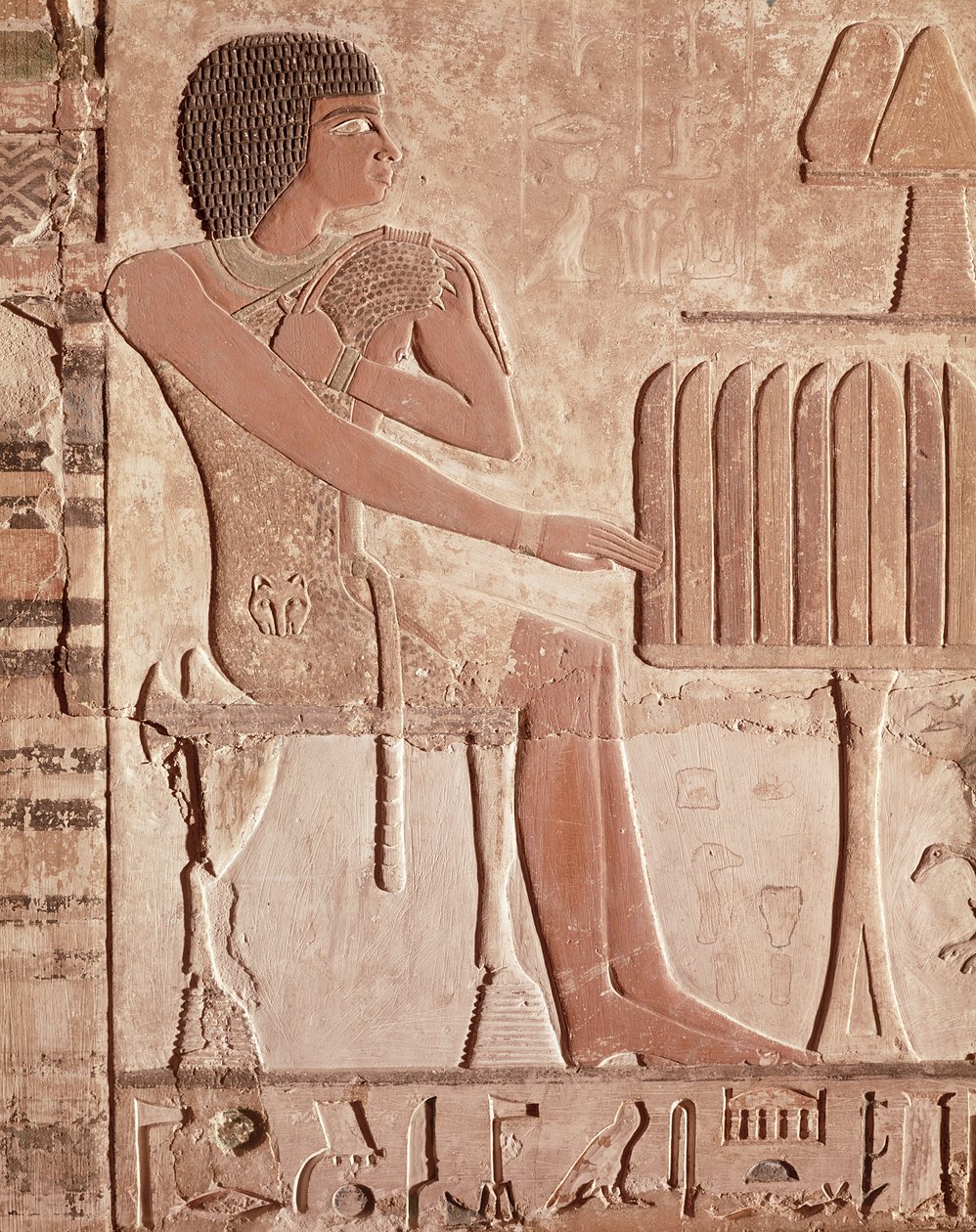 Relief som visar den avlidne sittande framför ett offerbord med bröd (målad sten) av Old Kingdom Egyptian