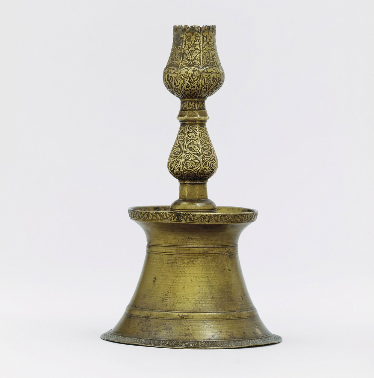 En ottomansk mässingsljusstake, halsen med inskuren arabeskdekor som stiger till formen av en tulpan av Ottoman School