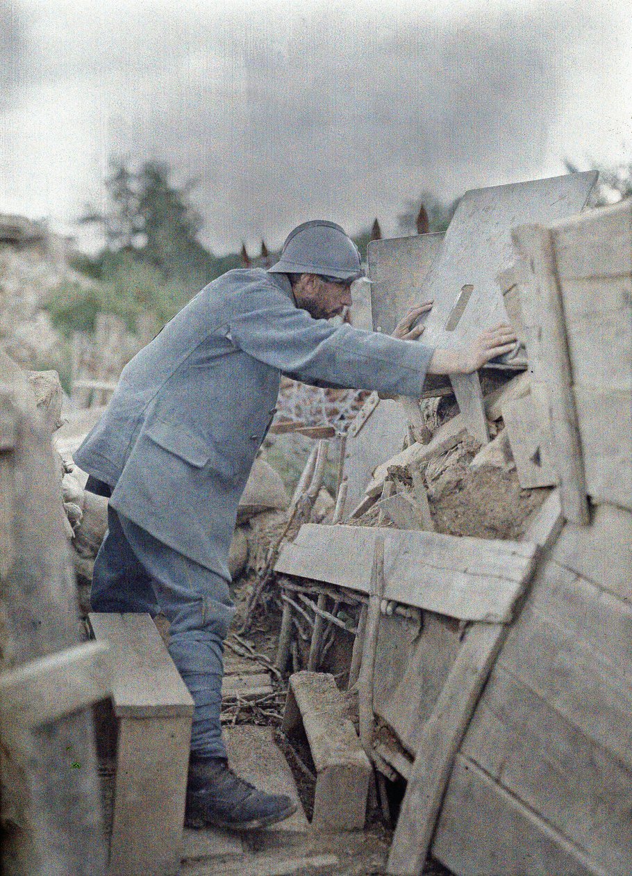 En fransk soldat i arméns utkik 26 tittar på området framför sig genom en skyddande metallsköld, Eglingen, Department Haut-Rhin, Alsace, Frankrike, 26 juni 1917 (autokrom) av Paul Castelnau