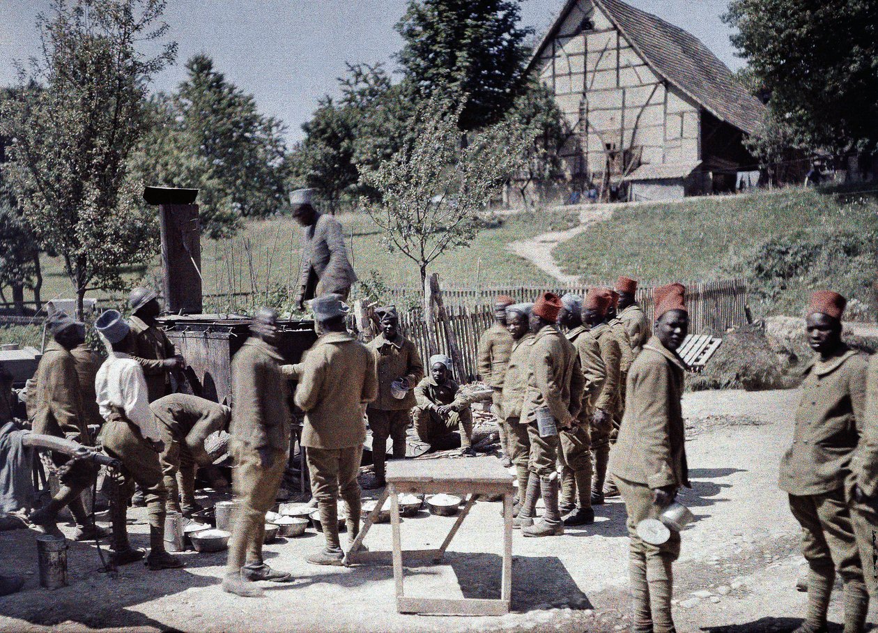 En grupp senegalesiska soldater som tjänstgör i den franska armén som infanterister äter lunch i Saint-Ulrich, departementet Haut-Rhin, Alsace, Frankrike, 16 juni 1917 (autokrom). av Paul Castelnau