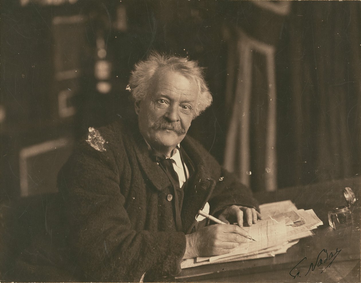 [Félix Nadar sitter vid ett skrivbord] av Paul Nadar
