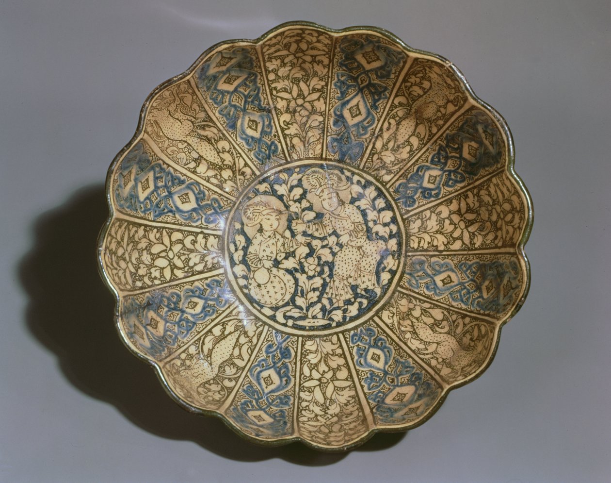 Vit lergodsskål målad i underglasyr av svart och blått med figurer av mongoler (keramik) av Persian School
