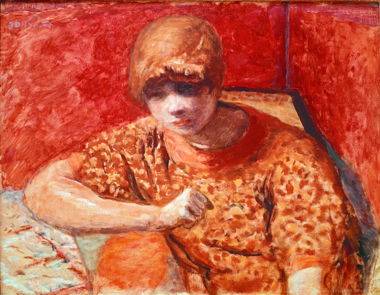 Den orange blusen Ung drömmande kvinna som sitter har ett bord på en röd bakgrund. Målning av Pierre Bonnard (1867-1947) 1913 Dim. 52x67 cm Paris, Privat samling av Pierre Bonnard