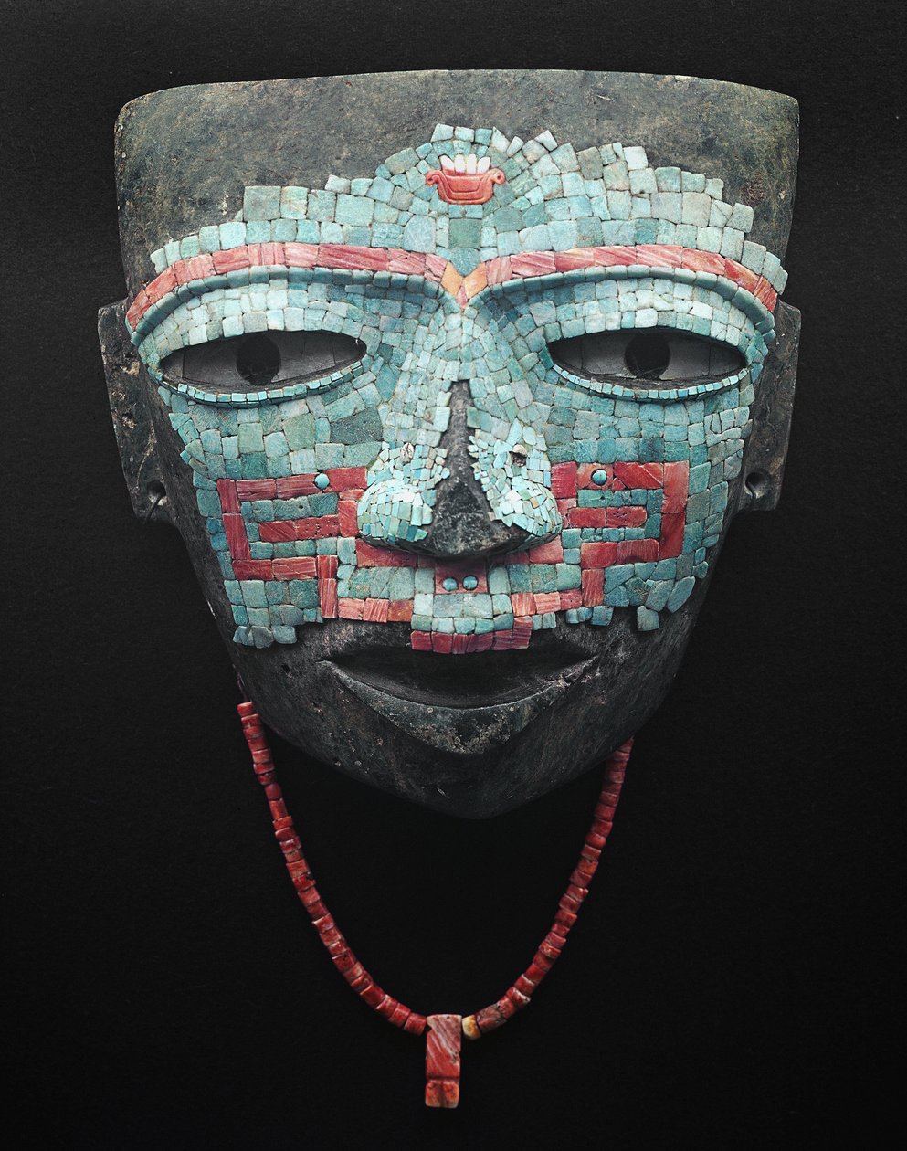 Begravningsmask täckt av turkos och röd skalmosaik. Artefakt från Teotihuacan, Mexico City. Teotihuacan Civilization - Precolombian konst: begravningsmask av turkosa och rosa stenar från civilisationen Teotihuacan III (300-650 e.Kr.) Mexiko. Mexi av Pre Columbian Pre Columbian