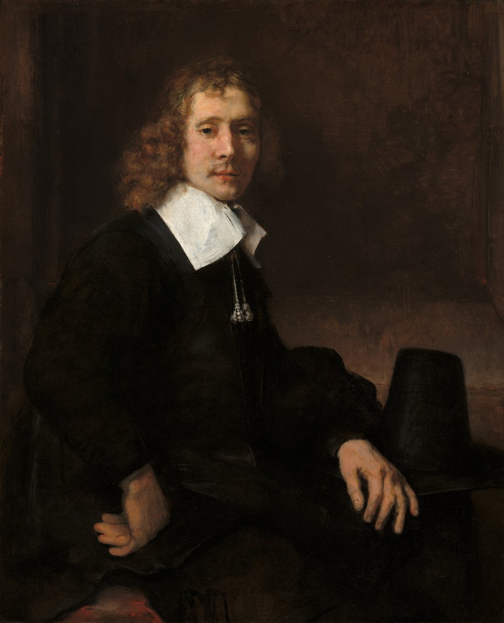 En ung man som sitter vid ett bord (möjligen Govaert Flinck) av Rembrandt van Rijn