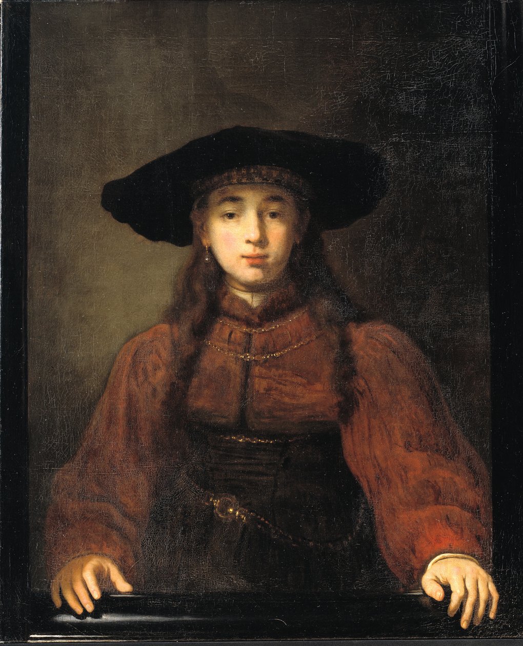 En ung kvinna vilar händerna på bildramen av Rembrandt van Rijn