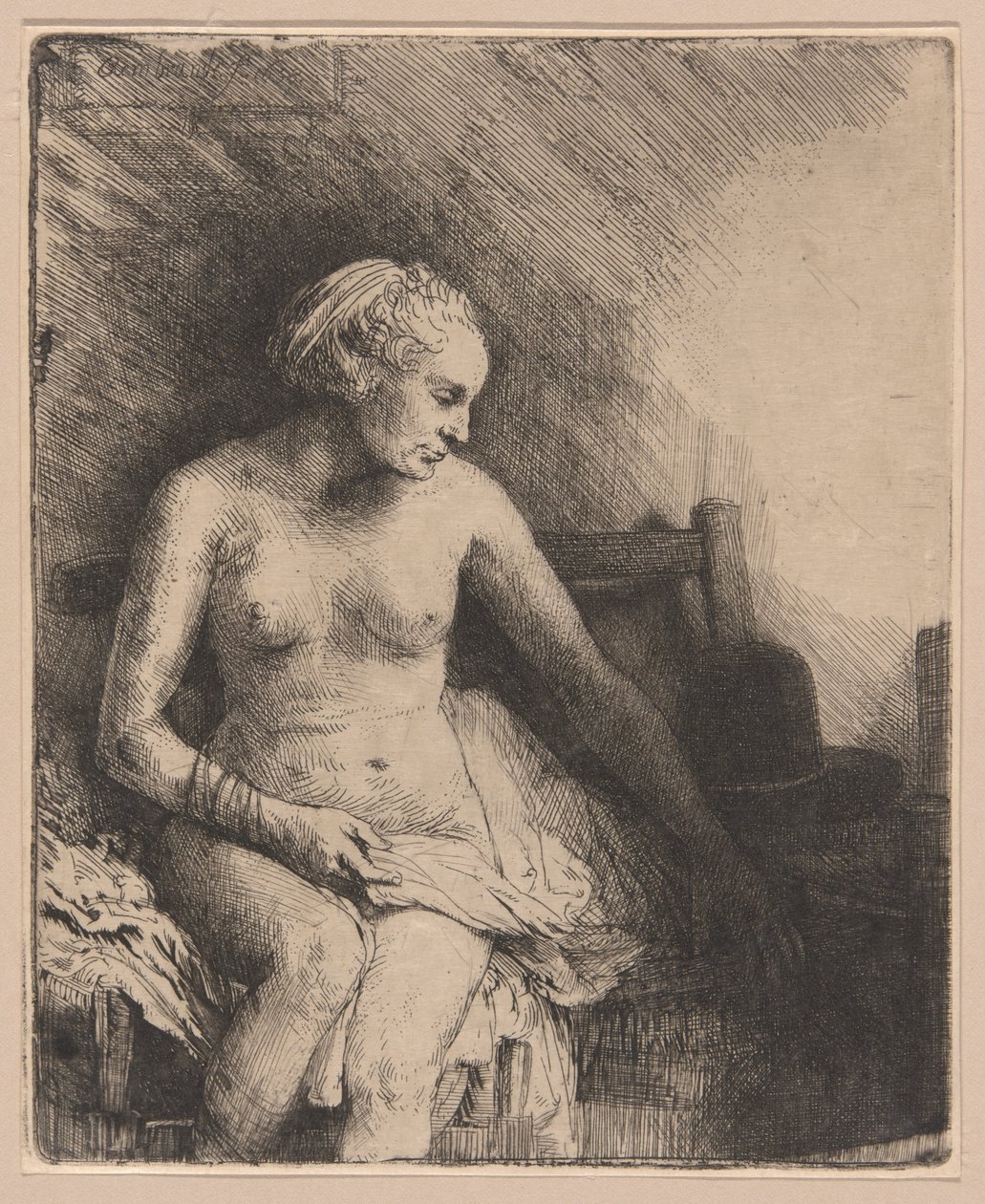 Kvinna vid badet med en hatt bredvid henne av Rembrandt van Rijn