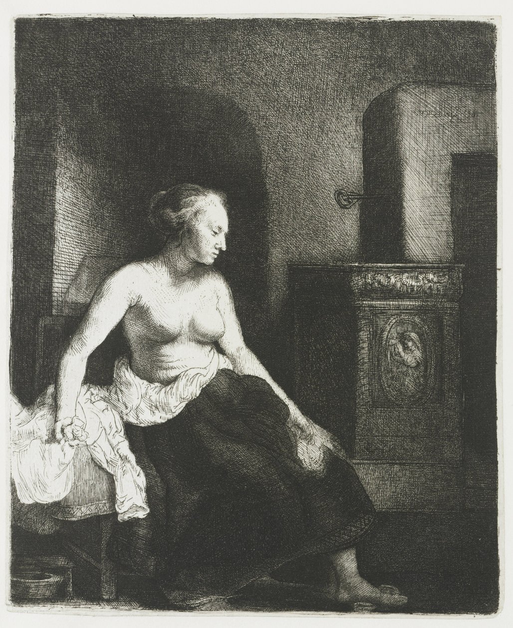 Kvinna som sitter halvklädd bredvid en spis av Rembrandt van Rijn